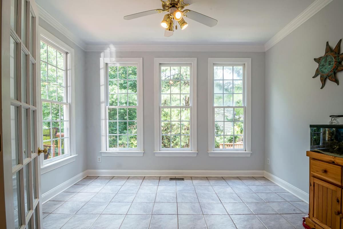 Sunroom before staging, tile floor and ceiling fan